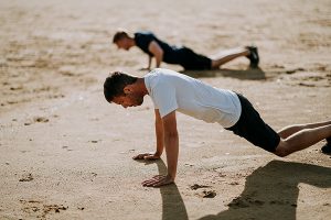 Two Men Doing Push Ups in the Sand