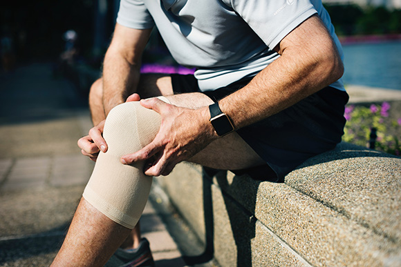 Man Holding Knee Braced