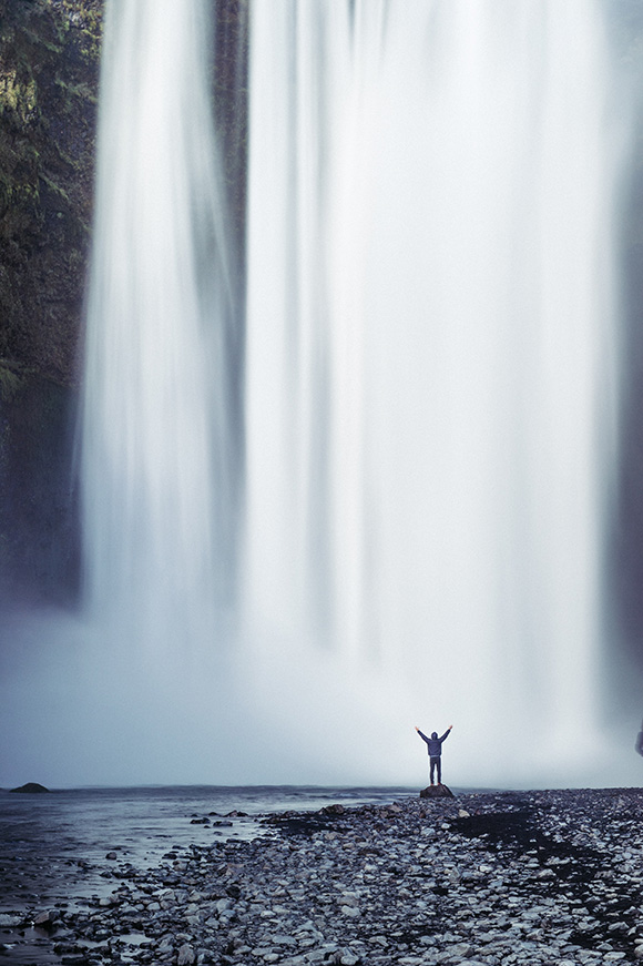 waterfall with person arms up