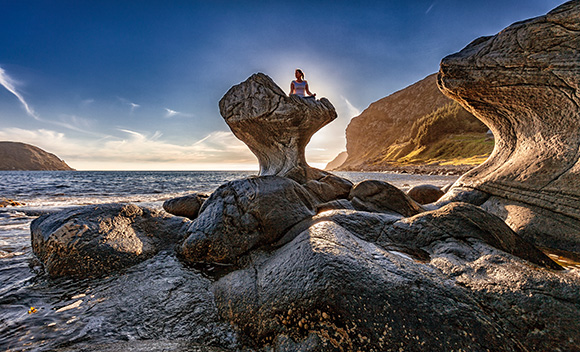 person meditating on a beautiful rock formation