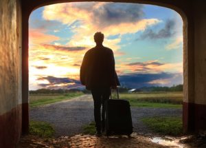 man with suitcase sunset