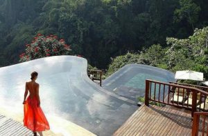 Woman in Red Dress overlooks Bali Hanging Gardens Infinity Pool Bali