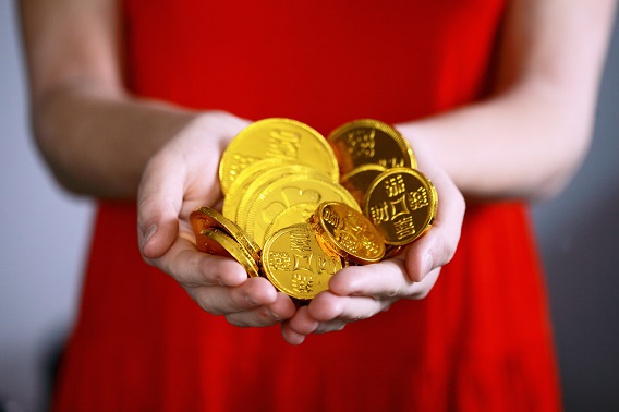 outstretched hands with gold coins