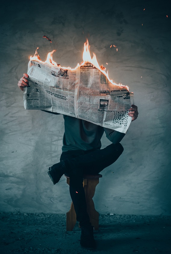 Man Reading Burning Newspaper