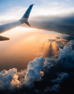 Plane Tail Above Clouds and Sun