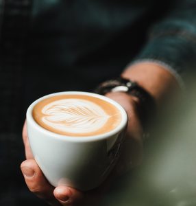 Cup Of Coffee With Artful Color in Hand