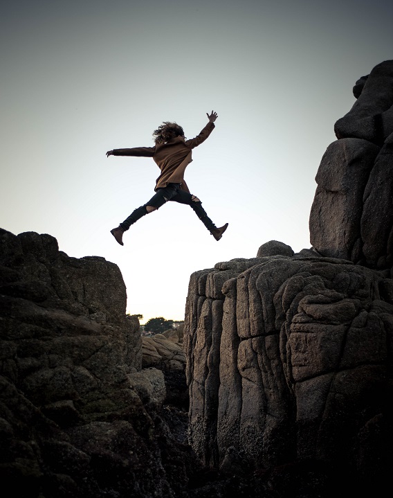 Woman Jumping From Cliff to Cliff