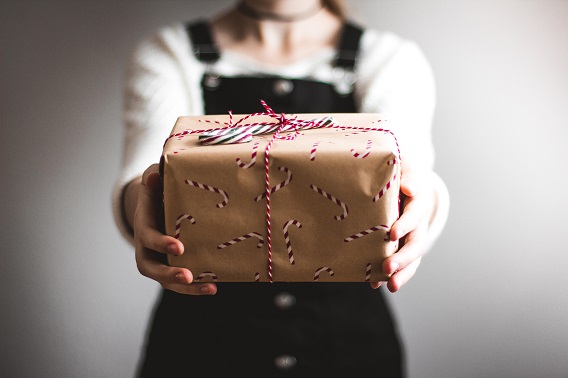 Person Handing Brown Present To First Person Viewer